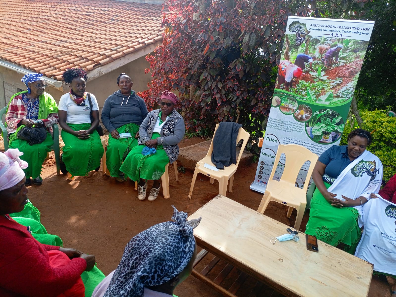 Volunteers and community organizers working alongside farmers in field training session, shadowed atmospheric environment with warm amber light accents
